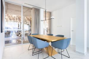 桑蒂亚戈德尔泰德Crystal I Luxury Apartments by EnjoyaHome的一间带木桌和蓝色椅子的用餐室