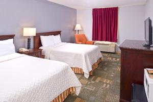 本顿Country Garden & Suites的酒店客房设有两张床和电视。