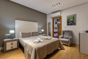 马德里BNBHolder Apartamentos en Sol Deluxe 1的一间卧室配有一张大床和毛巾