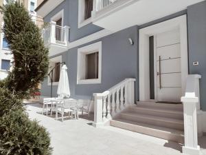 西尼加利亚Appartamento Stella Marina的蓝色的房子,设有白色的门和桌椅