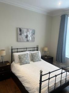 波尔蒙特1L Albert Place的一间卧室配有一张带2个床头柜的大床