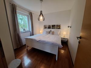 乌马格Apartments Villa Sotlar with pool的卧室配有白色的床和窗户。