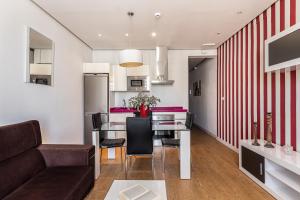 马德里BNBHolder Apartamentos en Sol Superior 2的厨房以及带桌椅的起居室。