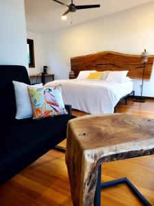 圣伊格纳西奥Yumas Riverfront Lodge的一间卧室配有一张床、一张沙发和一张桌子