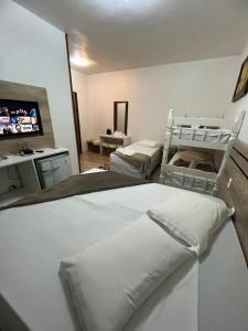 卡内拉Pousada Schmitz的一间卧室配有两张床和一台平面电视