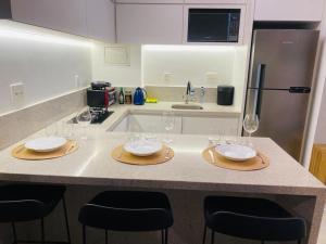 巴西利亚Apartamento novo de alto padrão e aconchegante#223的厨房配有带酒杯的桌子