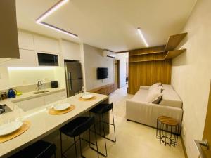 巴西利亚Apartamento novo de alto padrão e aconchegante#223的厨房以及带柜台和沙发的客厅。