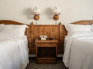 莱文沃思恩慈安旅馆的酒店客房设有两张床和一张桌子及电话