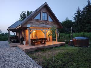 Domek z bala na Podlasiu z balią ogrodową的小屋设有木甲板、桌子和浴缸