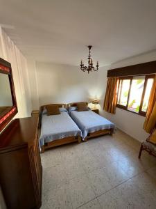 桑亨霍Apartamento en Nanin-Sanxenxo的一间卧室设有两张床、一张桌子和窗户。
