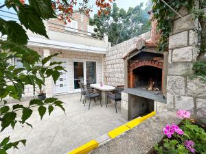 科尔丘拉Orhideja的庭院设有桌子和壁炉。