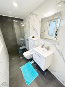 科尔丘拉Orhideja的白色的浴室设有水槽和卫生间。