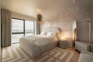 特罗姆瑟Vindlys Luxury Penthouse Apartment的一间卧室设有一张床和一个大窗户
