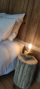 Coeur de ferme en Pévèle的一间卧室配有一张床和一张带台灯的桌子