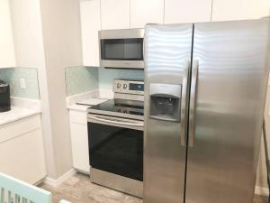 蓬塔戈尔达Modern Apartment - 1 of 4的厨房配有不锈钢冰箱和微波炉。