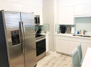蓬塔戈尔达Modern Apartment - 2 of 4的一间厨房内的不锈钢冰箱,厨房内有白色的橱柜