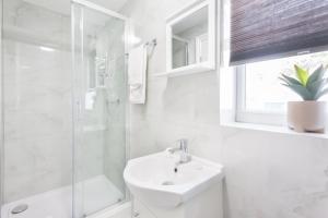 伦敦Holloway Budget Apartment - 1 Minute to Emirates Stadium - Next to Station - City Center的白色的浴室设有水槽和淋浴。