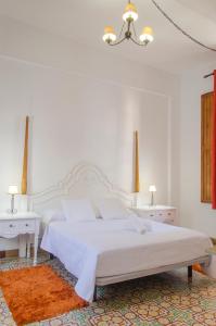 圭马尔Hotel rural casona Santo Domingo的白色卧室配有白色的床和2张白色桌子