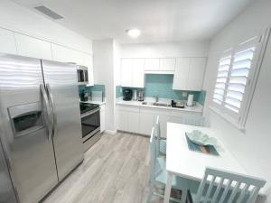 蓬塔戈尔达Modern Apartment - 4 of 4的厨房配有冰箱和桌椅