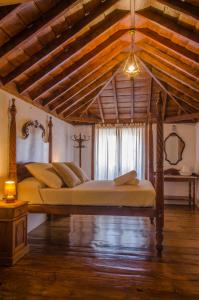 圭马尔Hotel rural casona Santo Domingo的一间卧室设有一张带木制天花板的大床