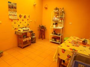 普诺La Casa del Manzano的厨房拥有橙色的墙壁、桌子、桌子和架子