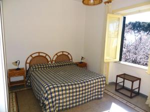 加埃塔B&B Villa Fantasia的一间卧室配有一张带 ⁇ 子毯子的床和窗户