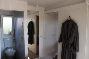 科兰Sha-Shaaa Luxury Mobile Home - Terra Park SpiritoS的浴室设有卫生间,门上挂着长袍