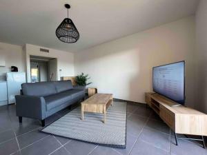 贝济耶App Le Golf T3 terrasse wifi pkg的带沙发、桌子和电视的客厅