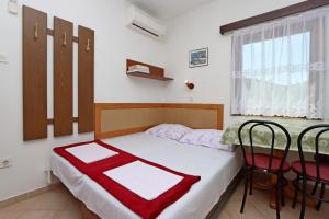 博罗维奇Apartments with a parking space Potocnica, Pag - 6338的一间卧室配有一张带桌椅的床