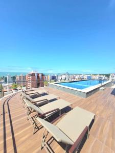 若昂佩索阿Apartamento praia Cabo Branco - João Pessoa的建筑屋顶上的一组躺椅