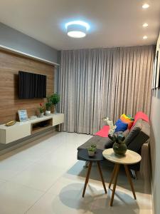 若昂佩索阿Apartamento praia Cabo Branco - João Pessoa的带沙发和电视的客厅