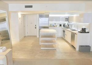 迈阿密海滩1 Hotel & Homes Miami Beach Oceanfront Residence Suites By Joe Semary的厨房配有白色橱柜和楼梯