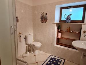 Gîte Méligny-le-Grand, 4 pièces, 6 personnes - FR-1-585-29的一间带卫生间和水槽的浴室以及一台电视。
