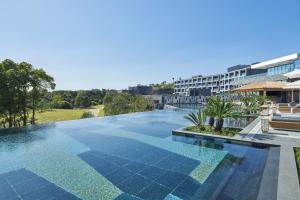 西归浦市JW Marriott Jeju Resort & Spa的一座带大楼的度假村的游泳池