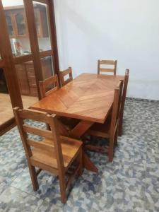 伊基托斯Casa Grande的木制餐桌,配有两把椅子和一张桌子及椅子
