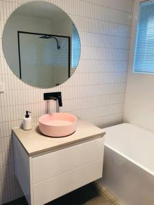 霍巴特The Blush House的浴室设有粉红色的盥洗盆和镜子