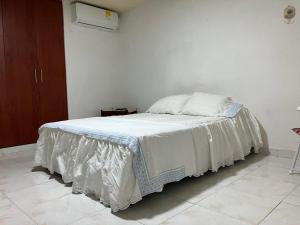 卡塔赫纳Casa Encanto Cartagena Colombia的一间卧室配有一张床铺,床上铺有白色毯子