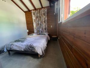 皮特尔角城Charmante Villa, kaz’ AA.Liyah的窗户客房内的小床