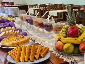 蒙特韦尔迪Pousada Monte Silvestre的餐桌上放有食物和酒杯的盘子