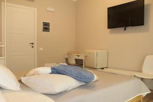 比萨Aurora BnB的卧室配有一张床铺,墙上配有电视