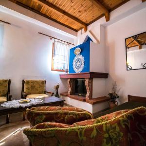 桑加拉达Αρχοντικό Κονάκι- Konaki Pelion的客厅设有壁炉、桌子和椅子