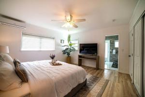 迈阿密Luxury Miami Village w/Pool+Grill+MiniGolf的一间卧室配有一张床和吊扇