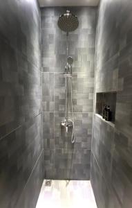 巴淡岛中心oxy suites G-03 at Shop House Meisterstadt Pollux Habibie的浴室设有灰色瓷砖淋浴。
