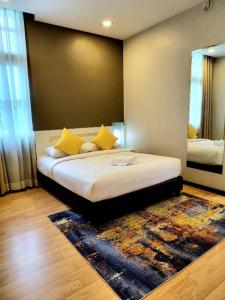 关丹Lovita Hotel Kuantan的一间卧室配有一张带黄色枕头和镜子的床