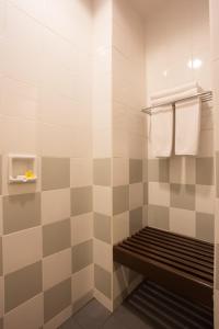 纳闽巴霍宾唐弗洛雷斯酒店的浴室内铺有瓷砖的淋浴和长凳