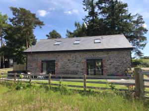 LlanwrthwlChic cottage near Elan Valley and Builth Wells的前面有围栏的石头房子