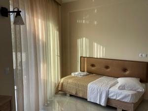 斯卡拉索提罗斯Green Memories的一间卧室配有一张带床头板和窗帘的床