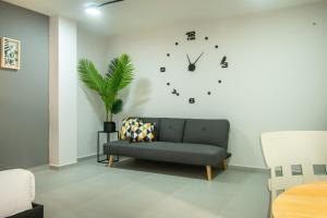 麦德林Barcelo Coliving的客厅配有沙发和墙上的时钟
