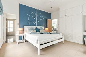 拉迈2BR Villa Baan Orchid, seconds to beach的卧室配有白色床和蓝色墙壁