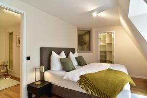莱比锡SAXX Apartments Leipzig的一间卧室配有带白色床单和绿色枕头的床。